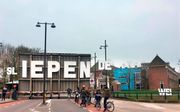 Maak de streektaal op straat zichtbaar, is het advies van de Friezen. Foto: De volledige straatnaam (die te vertalen is als ”slapende weg”) bij de Noorderbrug in Leeuwarden is pas te lezen als de brug open is („iepen” in het Fries).  beeld Aad van Altena