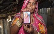 Op 27 juni werd de bedelares Shantadevi Nath (hier door haar nicht getoond op een portretfoto) in Ahmedabad door een menigte vermoord omdat ze er (ten onrechte) van werd verdacht kinderen te ontvoeren.  beeld AFP, Sam Panthaky