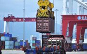 Containers worden op een vrachtwagen geladen in de haven van Qingdao, China. beeld AFP Photo