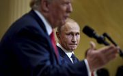 Poetin houdt zich angstvallig aan zijn stoel vast tijdens handdruk met Trump. beeld AFP, Alksey Nikolskyi
