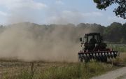 Een boer bij de Dikkenbergweg tussen Ede en Bennekom keert zijn tractor in een grote stofwolk, die vanwege de droogte is ontstaan. Een op de tien boeren wil zich niet aan het in sommige gebieden geldende beregeningsverbod houden, zo blijkt uit een peiling