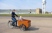 Duitse ouders hebben onder meer het Nederlandse bakfietsenmerk Babboe  ontdekt. Foto: een moeder fiets met haar kroost door het park bij het voormalige vliegveld Tempelhof in Berlijn. beeld Babboe