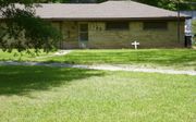 Bij sommige sympathisanten van de Ku-Klux-Klan staat een wit kruis in hun tuin. Inzet: bordje dat jaren bij de ingang van Vidor hing: ”Alleen blanken”. beeld RD/life2000.org