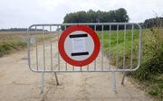 De toegangsweg naar een boerderij bij het dorp Etalle in Belgisch Luxemburg was vrijdag afgesloten voor onbevoegden. Aanleiding is de uitbraak van Afrikaanse varkenspest onder wilde zwijnen in de omgeving. beeld EPA, Julien Warnan