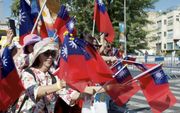 Vrouwen uit Taiwan zwaaien met de vlag van hun land. Ze maken deel uit van een groep van duizenden christenen die donderdag meedeed aan een drie kilometer lange wandeltocht door Jeruzalem, ter gelegenheid van het Loofhuttenfeest. beeld RD