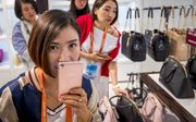 Chinese toeristen bezoeken in Roermond  een winkel met luxe tassen. beeld ANP, Marcel van Hoorn