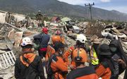 Reddingswerkers overleggen in het zwaargetroffen gebied rond Palu, op het Indonesische eiland Sulawesi. beeld EPA, Mast Irham