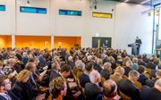 Een volle zaal zaterdag tijdens het symposium in Dordrecht. Vooraan: dagvoorzitter ds. P. Mulder. beeld Cees van der Wal