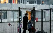 Een ouder brengt zijn kinderen naar de orthodox-Joodse school het Cheider in Amsterdam. De school ligt onder een vergrootglas van de onderwijsinspectie. beeld ANP, Robin van Lonkhuijsen