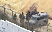 Aan de noordgrens staat Israël er praktisch alleen voor. Foto: Israëlische soldaten bij de bijna voltooide, tien meter hoge muur die Israël en Libanon strikter van elkaar moet scheiden. beeld AFP, Mahmoud Zayyat