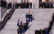 Leden van de erewacht dragen de kist met lichaam van George H. W. Bush de trappen van het Capitool in Washington op. Daar lag de oud-president opgebaard. Na de herdenkingsdienst in de National Cathedral werd de oud-president naar Houston overgevlogen om d