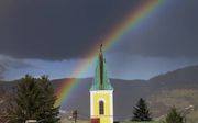 De regenboog rond de troon laat zien dat God trouw is aan Zijn verbond. beeld iStock