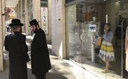 Onderonsje tussen twee ultraorthodoxe Joden in de Israëlische stad Bnei Brak. beeld Alfred Muller