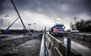 Een elektrische vrachtwagen rijdt ter opening over het eerste betonnen herbruikbare viaduct –een testversie– aan de Dronter zijde van het Drontermeer. De elementen van het kustwerk kunnen na demontage weer elders worden gebruikt. Rijkswaterstaat wil zo de