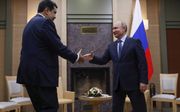 President Maduro (l.) van Venezuela reikt de hand aan zijn Russische collega Poetin tijdens zijn bezoek aan Moskou in december.  beeld EPA, Maxim Shemetov