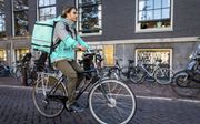 Online bezorgdiensten als Deliveroo zijn een schoolvoorbeeld van de zogenaamde platformeconomie. Foto: bezorger van Deliveroo in centrum van Amsterdam. beeld ANP, Sem van der Wal
