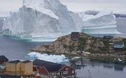 Ijsberg drijft voorbij dorpje op Groenlands. beeld EPA, Karl Petersen