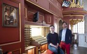 Baptiste-Florian Marle-Ouvrard (r.) en Thomas Ospital bij de speeltafel van het orgel in de Rotterdamse Laurenskerk. beeld Sjaak Verboom