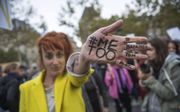 MeToo kreeg wereldwijd navolging. Franse vrouwen protesteren in 2017 tegen seksueel geweld tegen vrouwen. ”Verlink je varken”, staat op de hand van deze activist. beeld EPA, Christophe Petit Tesson