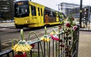 Bloemen op het hek bij de tram op het 24 Oktoberplein, waarin zich maandagochtend een schietpartij voordeed. Bij het misdrijf kwamen drie mensen om het leven. Politie en anti-terreureenheden openden een klopjacht op de dader, die ’s avonds kon worden opge