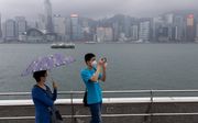 Chinese toeristen met mondkapjes in Hong Kong. beeld EPA