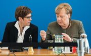 CDU-kopstukken Annegret Kramp-Karrenbauer (l.) en  Angela Merkel (r.). beeld EPA, Jens Schlueter