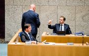 Minister De Jonge (r.) steekt een dikke duim op naar minister Grapperhaus (m.) als die na een korte ondervraging door de Kamer de vergaderzaal weer verlaat. beeld ANP, Bart Maat