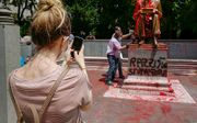 Betogers bekladden in Milaan het standbeeld van de journalist Indro Montanelli. beeld  EPA, Andrea Fasani