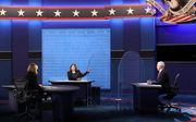 De kandidaten voor het Amerikaanse vicepresidentschap Kamala Harris (m.) en Mike Pence (r.) gingen afgelopen nacht met elkaar in debat. beeld EPA