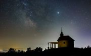 De Melkweg is te zien aan een heldere hemel boven de kapel Saint Anne bij het dorp Abasar in Hongarije. beeld EPA
