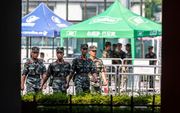 Leden van de Chinese militaire politie  patrouilleren donderdag in Shenzen, dat grenst aan Hongkong.  beeld  EPA, Alex Plavevski