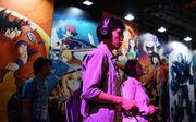 Bezoekers van een computerbeurs in Tokio spelen games. beeld AFP, Chalry Triballeau