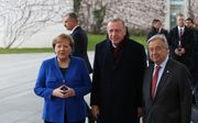 De Duitse bondskanselier Angela Merkel (l.) met de Turkse president Recep Tayyip Erdogan (m.) en VN-secretaris-generaal Antiono Guterres (r.) op de Libiëtop in Berlijn. beeld AFP, Murat Kula
