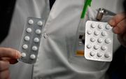 Medisch personeel van een universiteit in Marseille tonen tabletten met chloroquine. beeld AFP, Gerard Julien