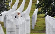 Een Bosnische vrouw tussen de graven van het herdenkingscentrum Potocari bij Srebrenica. beeld AFP