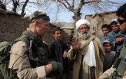 Nederlandse militairen in gesprek met de bewoners van de Choravallei in Uruzgan, Afghanistan in 2010. beeld AFP