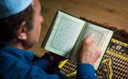 Een man leest de Koran. beeld ANP