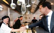 Premier Mark Rutte groet een werknemer van een restaurant in Almelo dat wordt gerund door mensen met een licht verstandelijke beperking. beeld ANP, Piroschka van de Wouw
