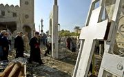 Iraakse christenen inspecteren een kerk die getroffen werd door een autobomaanslag. beeld AFP, Ahmad al-Rubaye