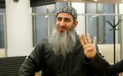 Fundamentalistische islamprediker Mullah Krekar in een rechtbank in Oslo in 2015. Hij maakt het Rabbi'ah-teken, dat door leden van de Moslimbroederschap vaak gebruikt wordt. beeld AFP