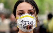 Een demonstrante demonstreert voor aanpak van klimaatverandering nu Australie getroffen wordt door bosbranden die voor smog zorgen tot in Sydney. beeld AFP