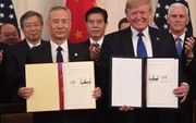 Liu He en Donald Trump met hun overeenkomst. beeld AFP