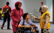 Reizigers op een vliegveld in Jakarta, Indonesië, worden gecontroleerd. beeld EPA