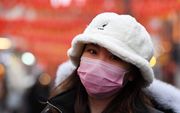 Een vrouw in Londen draagt een mondkapje. Het virus zou al in de stad kunnen rondwaren, stelde de minister van Volksgezondheid van het Verenigd Koninkrijk. beeld EPA