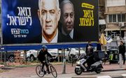 Een verkiezingsposter in Ramat Gan in Israël, met links Benny Gantz en rechts Benjamin Netanyahu. beeld AFP