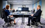 Koning Willem-Alexander neemt deel aan een videoconferentie met buitenlandse ambassades tijdens een werkbezoek aan het 24/7 BZ contactcentrum van Buitenlandse Zaken, dat zich bezig houdt met de repatriëring van reizigers die zijn gestrand door het coronav