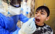 Een Irakese jongen wordt getest op het coronavirus. beeld AFP