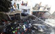 Reddingswerkers zoeken naar overlevenden op de plaats van het ongeval in Karachi, Pakistan. beeld EPA