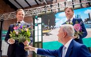 CDA-partijvoorzitter Rutger Ploum (m.) reikt bloemen uit aan de nieuwe partijleider Hugo de Jonge (l.) Rechts diens tegenkandidaat, Kamerlid Pieter Omtzigt. beeld ANP, Sem van der Wal