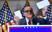 Rudy Giuliani, Trumps persoonlijke advocaat, houdt een envelop van een stembiljet in zijn handen tijdens een persconferentie. beeld AFP, Mandel Ngan